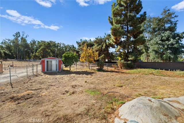 view of yard featuring a rural view and a storage unit