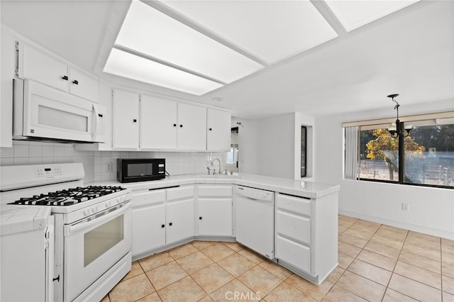 kitchen with kitchen peninsula, decorative backsplash, white appliances, white cabinets, and tile counters