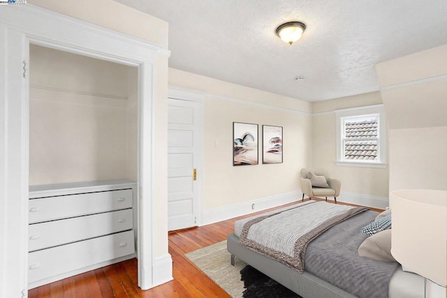 bedroom with hardwood / wood-style flooring and a textured ceiling