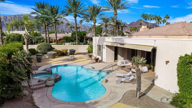 view of swimming pool with a mountain view, a patio, and an in ground hot tub