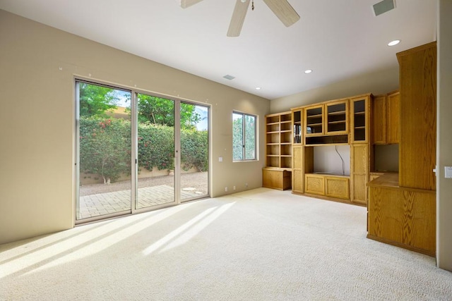 unfurnished living room featuring light carpet and ceiling fan