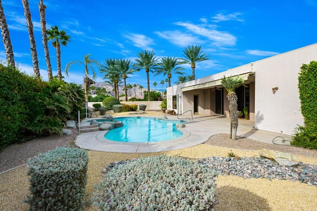 view of pool with a patio area and an in ground hot tub