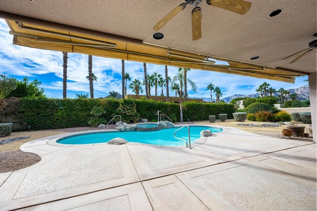 view of swimming pool with a mountain view, ceiling fan, and a patio