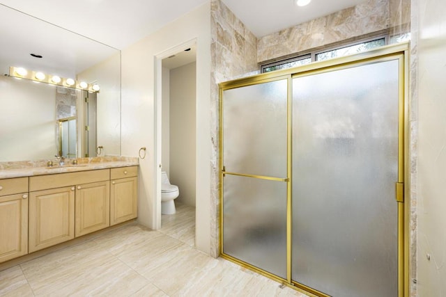 bathroom with vanity, toilet, and walk in shower