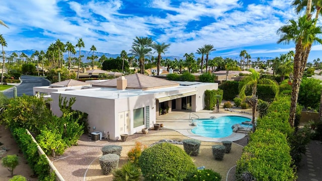 rear view of property featuring a patio area, a mountain view, and central AC