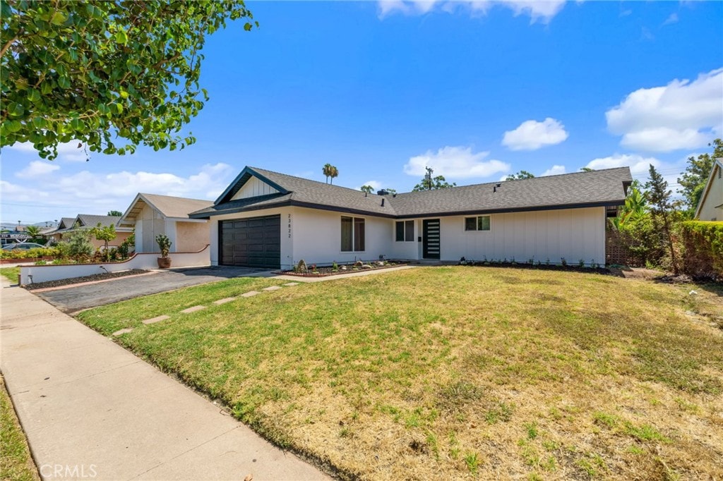 ranch-style home with a garage and a front lawn