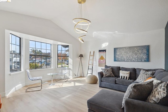 living room with light hardwood / wood-style flooring, lofted ceiling, and a notable chandelier