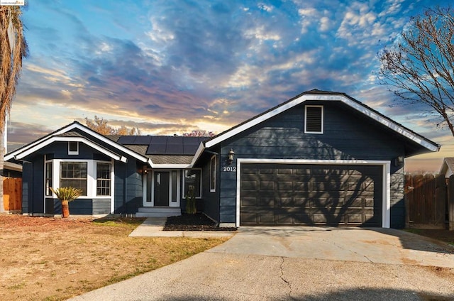 single story home with solar panels and a garage