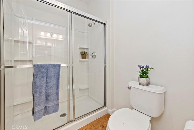 bathroom with toilet, wood-type flooring, and walk in shower