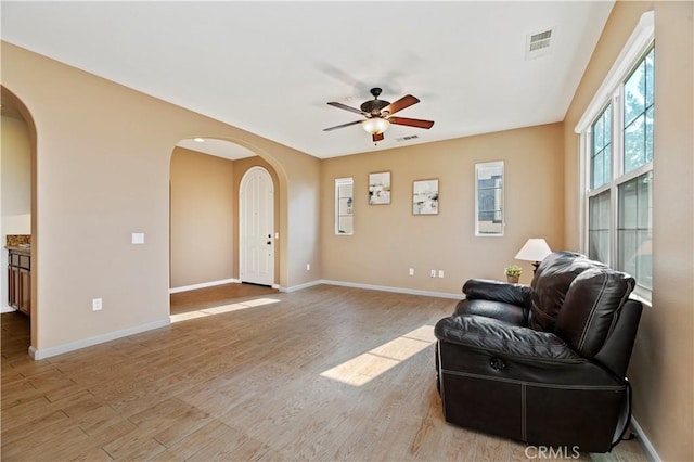 living room with ceiling fan and light wood-type flooring