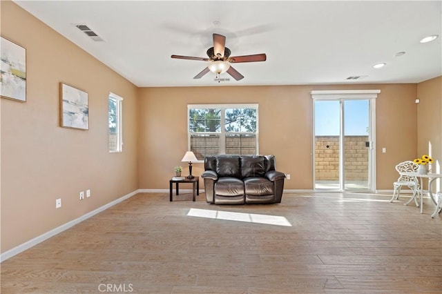 living area with ceiling fan and light wood-type flooring