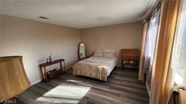 bedroom with a textured ceiling and dark hardwood / wood-style floors