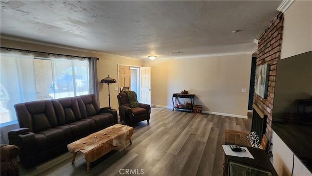 living room featuring hardwood / wood-style floors, a brick fireplace, and ornamental molding