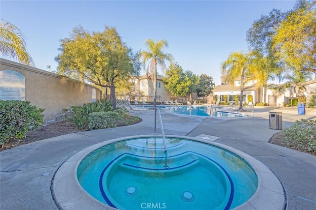 view of swimming pool featuring a hot tub