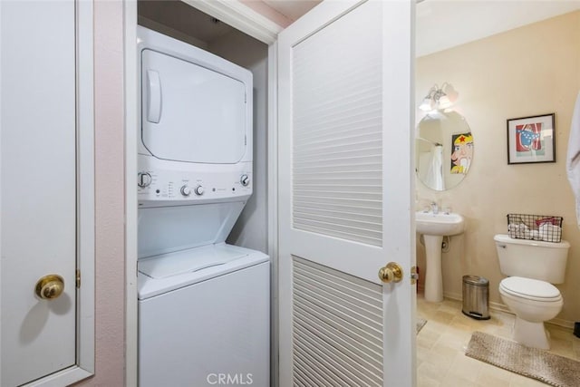 laundry room featuring sink, stacked washer and dryer, and light tile patterned flooring