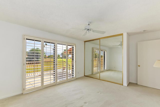 unfurnished bedroom with ceiling fan, light colored carpet, and a closet