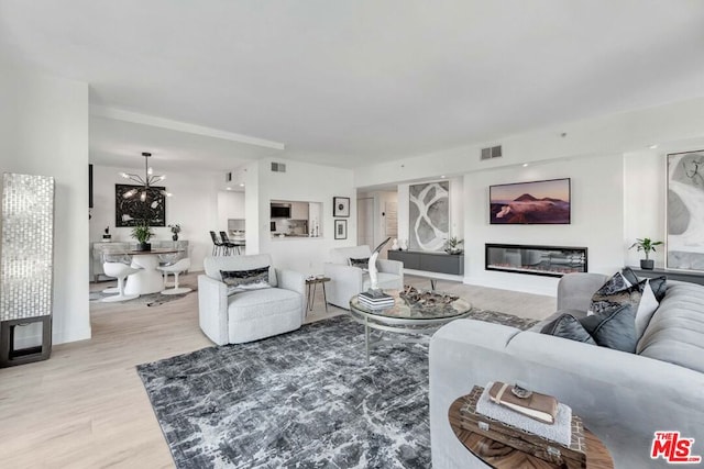 living room featuring a notable chandelier and light wood-type flooring