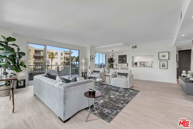 living room featuring a chandelier and light hardwood / wood-style floors