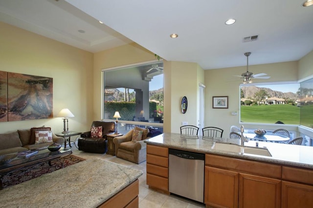 kitchen featuring dishwasher, sink, ceiling fan, light stone countertops, and light tile patterned flooring