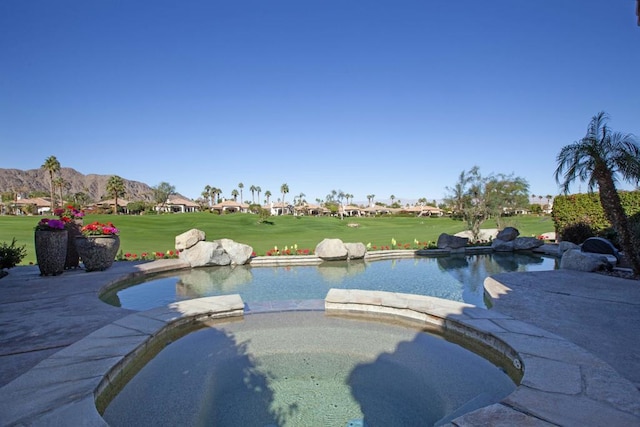 view of pool with a lawn, an in ground hot tub, and a mountain view