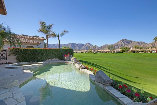 view of pool featuring an in ground hot tub, a yard, and a mountain view