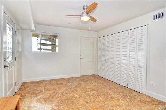 unfurnished bedroom with ceiling fan and a closet