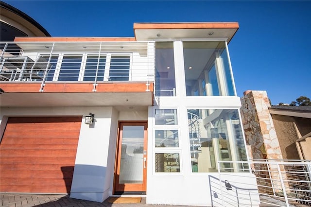 back of property with a garage and a balcony