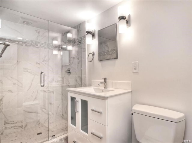 bathroom featuring vanity, toilet, and a shower with shower door