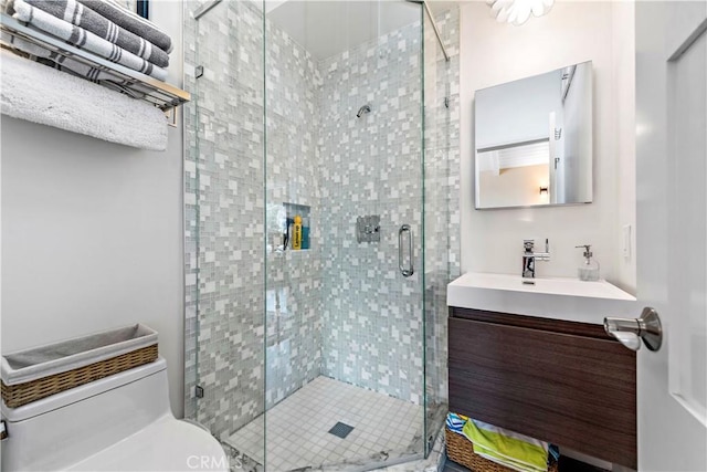 bathroom featuring vanity, toilet, and a shower with door