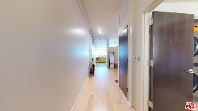 corridor with light hardwood / wood-style flooring and crown molding