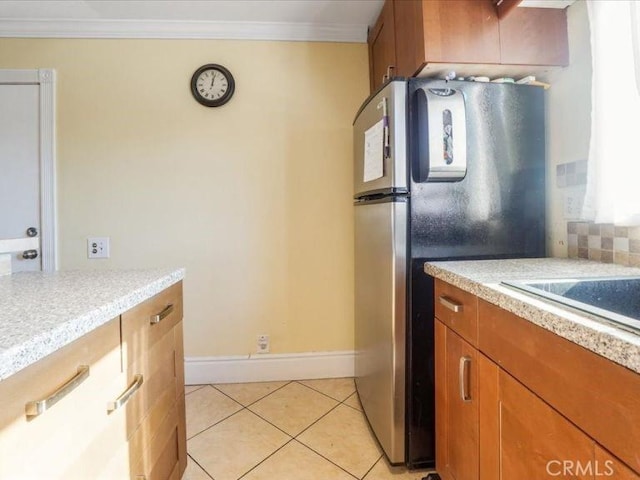 kitchen featuring stainless steel fridge, ornamental molding, and light tile patterned flooring