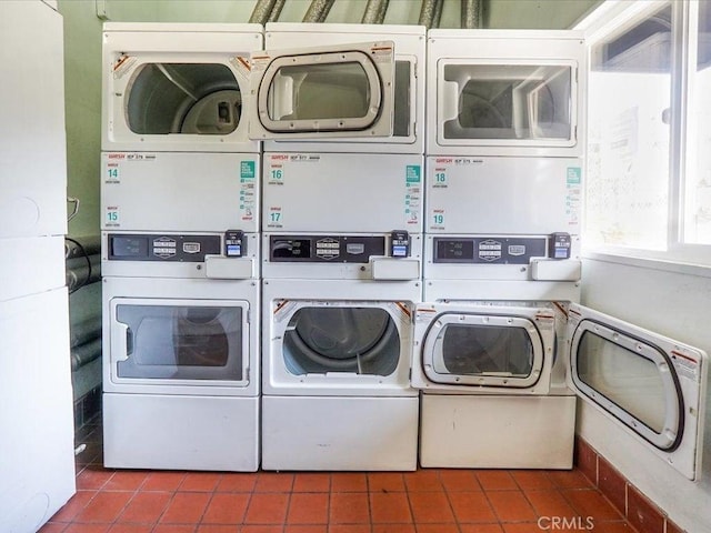 laundry room featuring stacked washer / drying machine, washer and clothes dryer, and tile patterned flooring