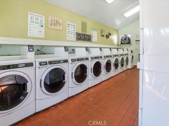 laundry area with dark tile patterned floors and independent washer and dryer