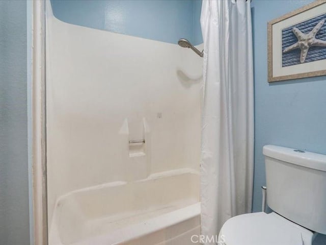 bathroom featuring shower / tub combo and toilet