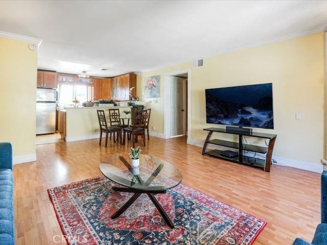 living room featuring ornamental molding and light wood-type flooring