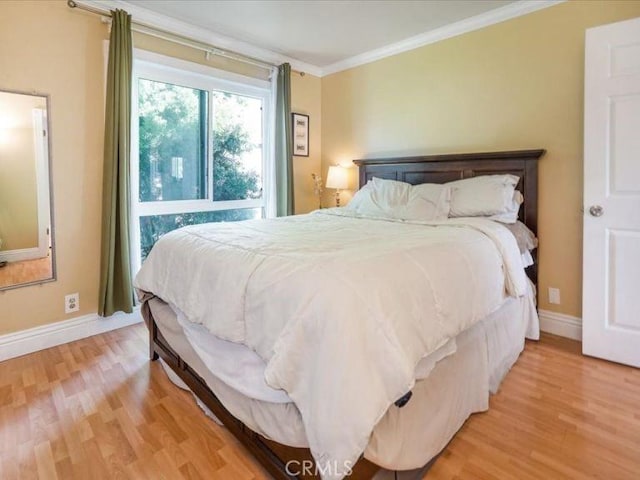 bedroom with ornamental molding and light hardwood / wood-style flooring