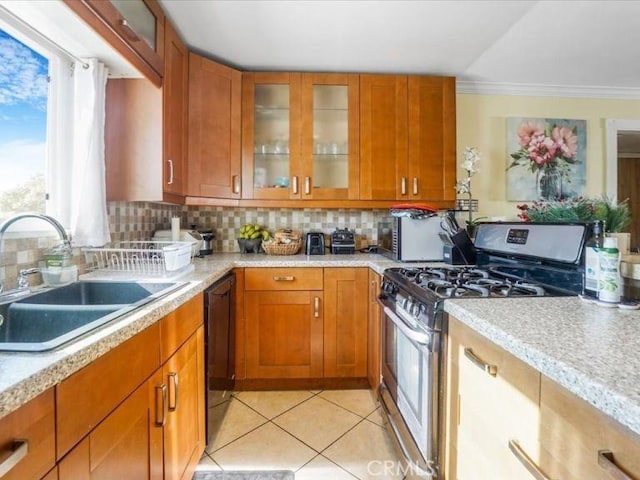 kitchen with sink, light tile patterned floors, dishwasher, backsplash, and stainless steel gas range oven