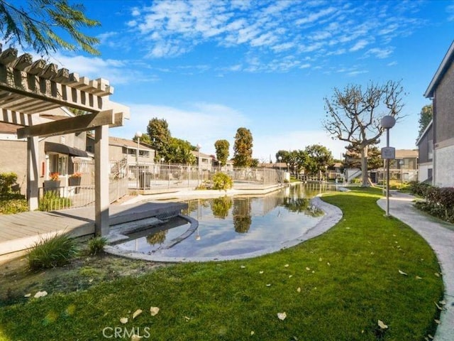 view of home's community featuring a water view, a pergola, and a lawn