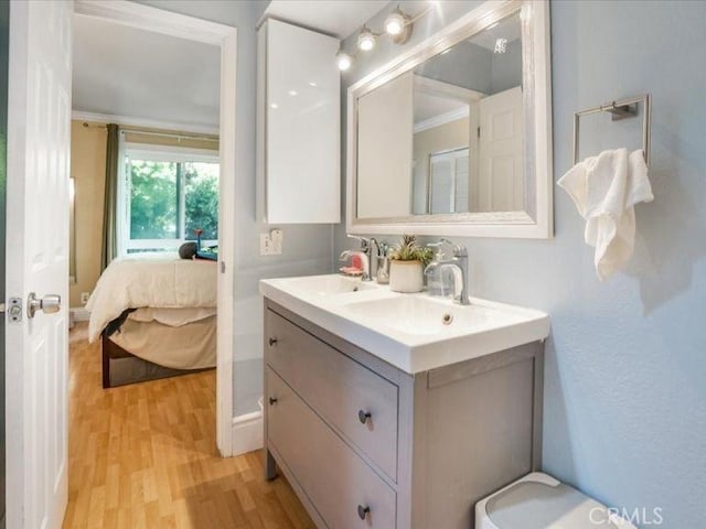 bathroom featuring vanity, hardwood / wood-style floors, and crown molding