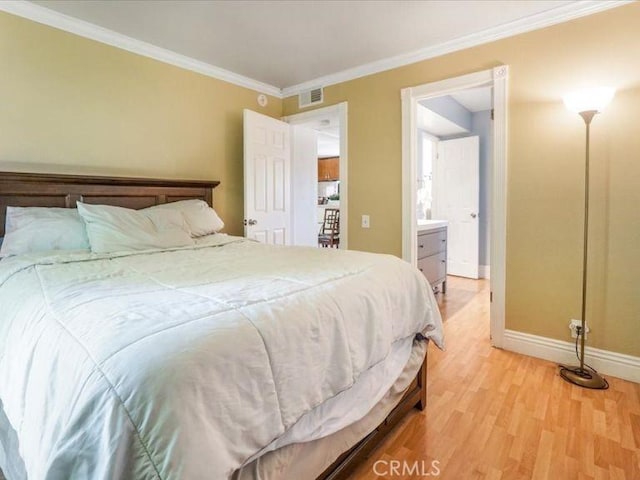 bedroom featuring connected bathroom, wood-type flooring, and ornamental molding