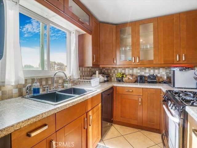 kitchen featuring sink, dishwasher, stainless steel gas stove, light tile patterned flooring, and decorative backsplash