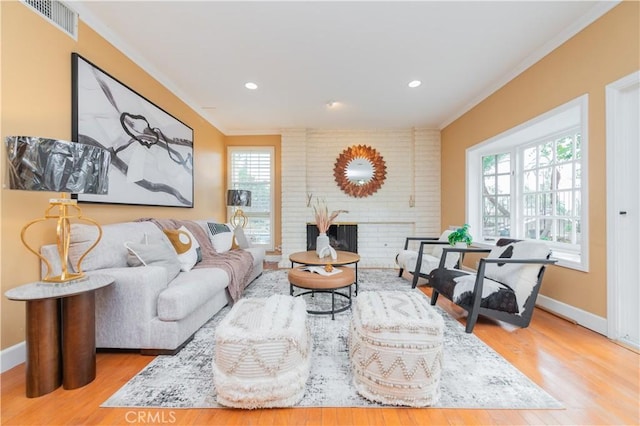 living room with light wood-type flooring, a fireplace, and a wealth of natural light