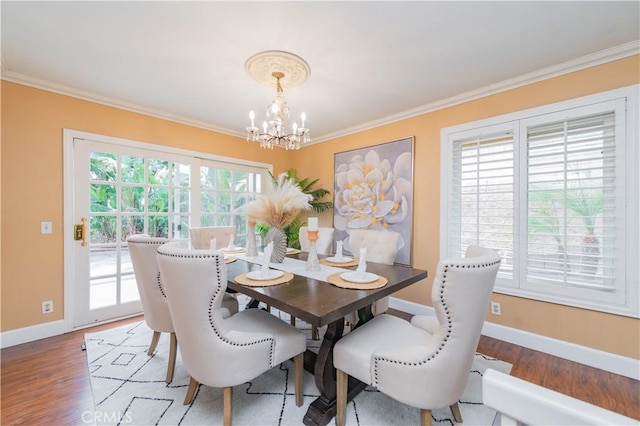 dining space with a notable chandelier, wood-type flooring, and crown molding