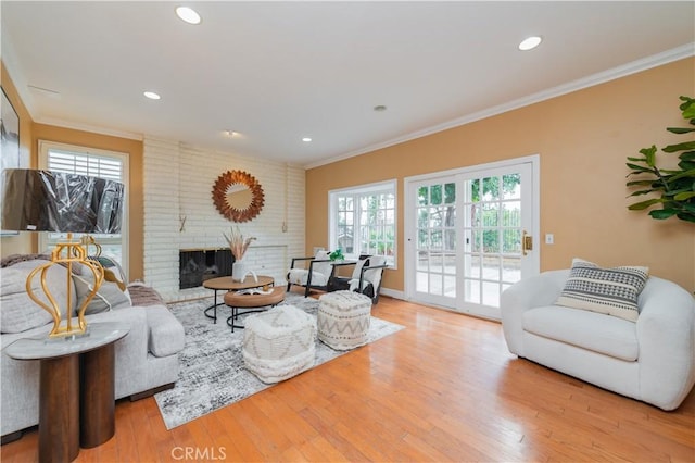 living room with a fireplace, light hardwood / wood-style floors, and ornamental molding