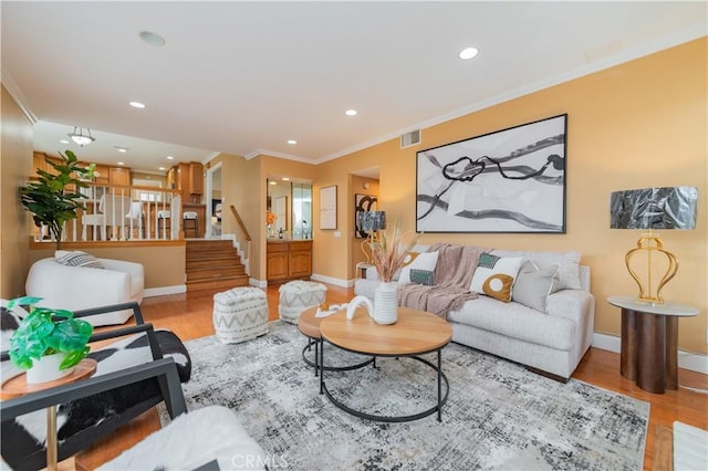 living room with crown molding and light hardwood / wood-style flooring