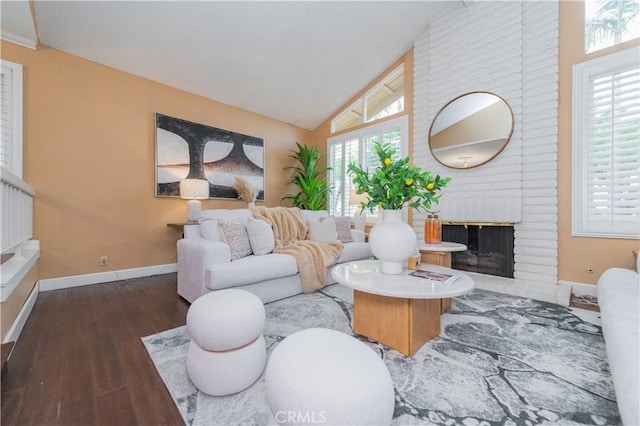 living room with dark hardwood / wood-style floors, vaulted ceiling, and a brick fireplace