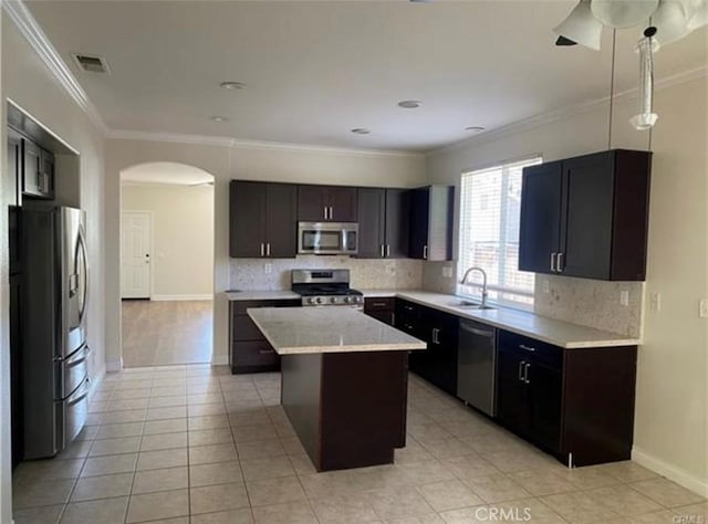 kitchen with a center island, ornamental molding, tasteful backsplash, dark brown cabinets, and stainless steel appliances