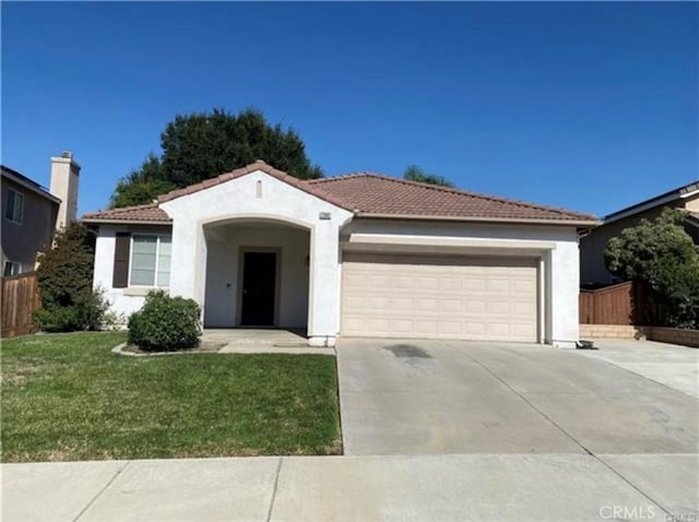 view of front of home with a garage and a front lawn