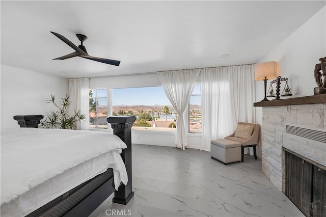 bedroom with ceiling fan and a fireplace