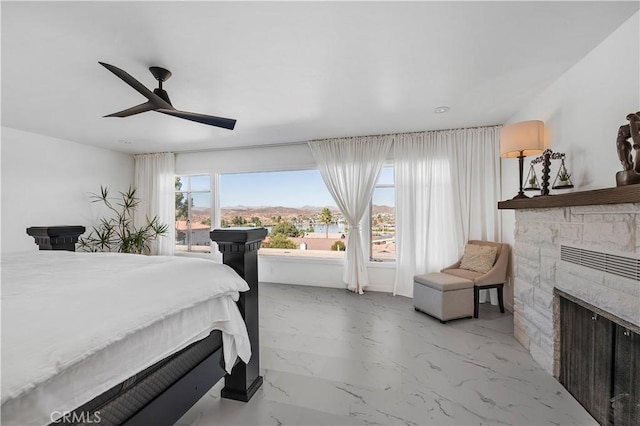 bedroom with ceiling fan and a fireplace